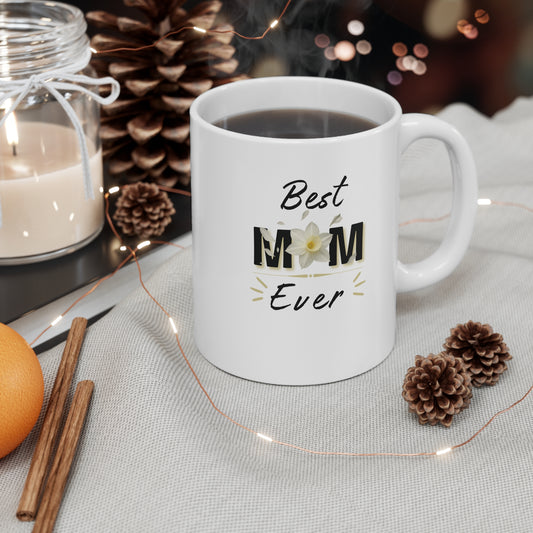 White mug with 'Best Mom Ever' text on a table with decorative items